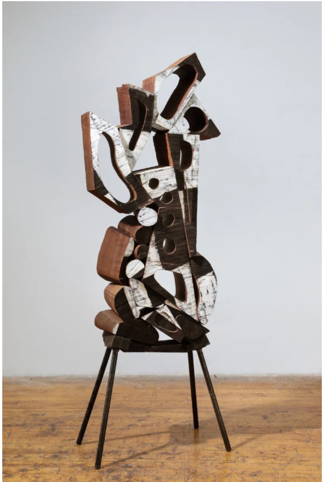Carved and painted wood sculpture on a yellow pedestal