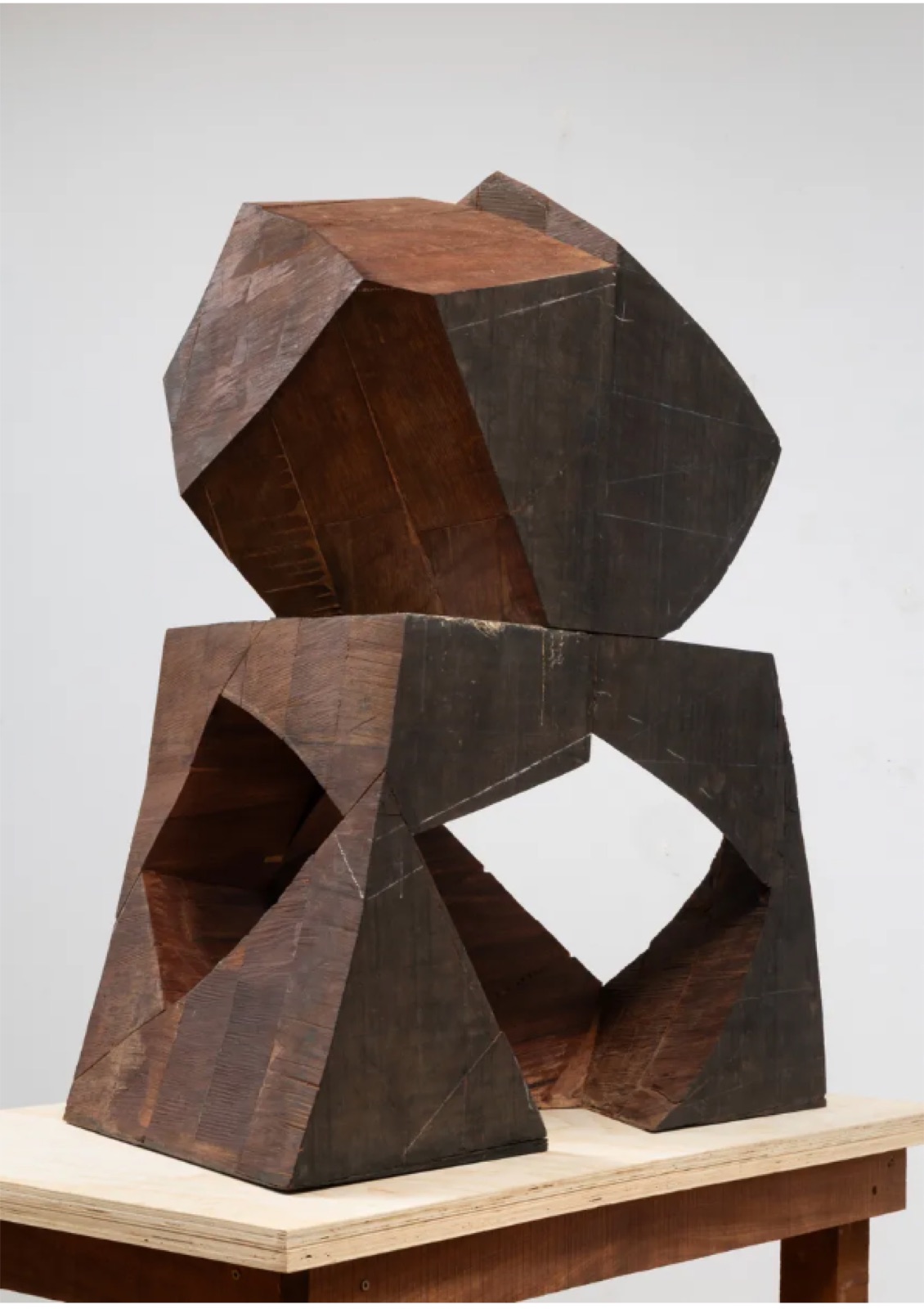 Faceted black sculpture stacked on a pale block